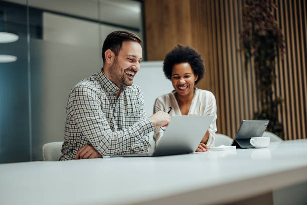 istock Joyful caucasian male, reading an e-mail he received to his coworker. 1360025257