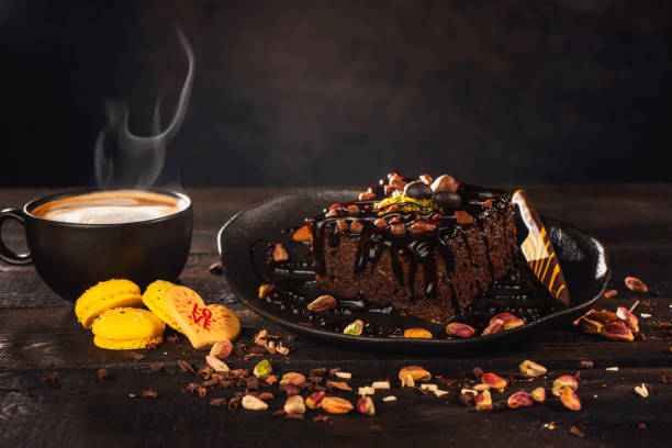 Latte art coffee cup with brownie in dish on wooden table at coffee shop..