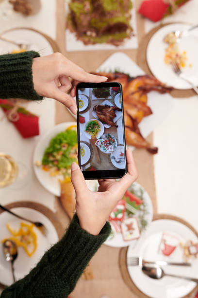 istock Woman Photographing Christmas Dinner Table 1360025511