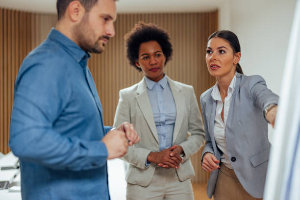 istock Two diverse adult colleagues, presenting their idea to their boss. 1360026846