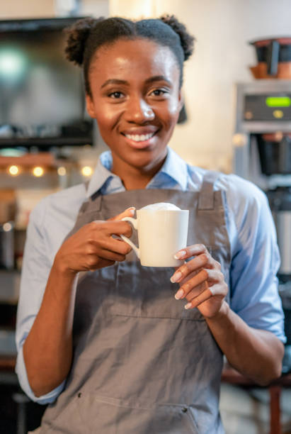 istock Smiling barista with a cappuccino 1360027993