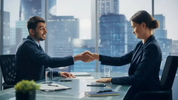 Photo of Female and Male Business Partners Sign Successful Deal Documents in Meeting Room Office. Corporate CEO and Investment Manager Agreed on a Lucrative Financial Opportunity.