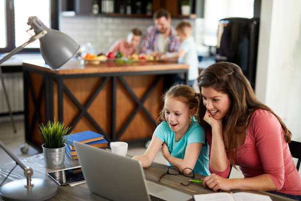 istock Mother helping her daughter with homework using laptop 1360028604