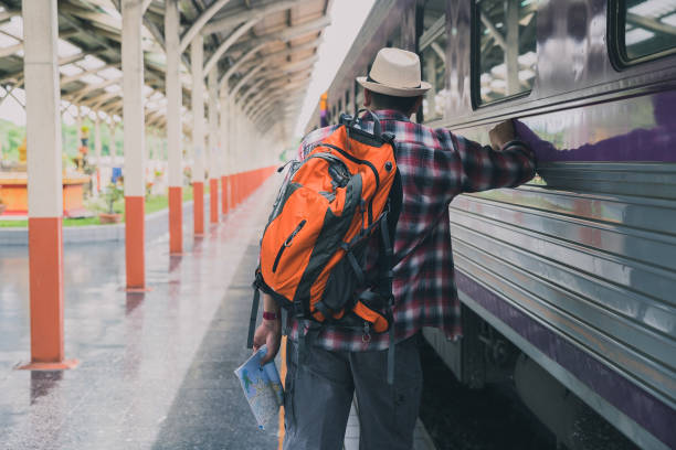 Traveler with backpack in train station. Travel concept. stock photo