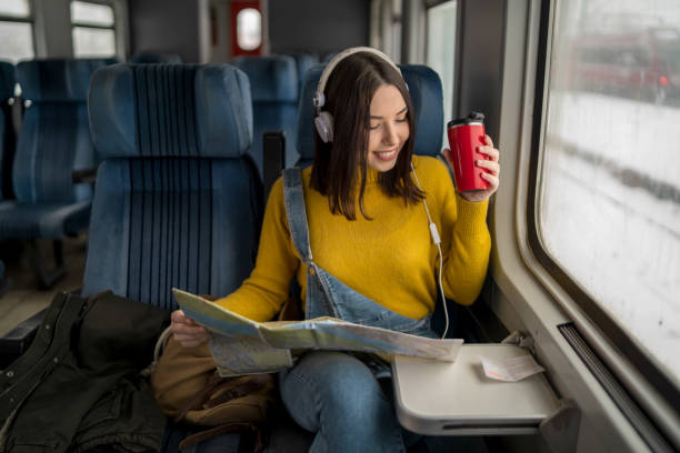 istock Young woman in train is reading a map 1360030707
