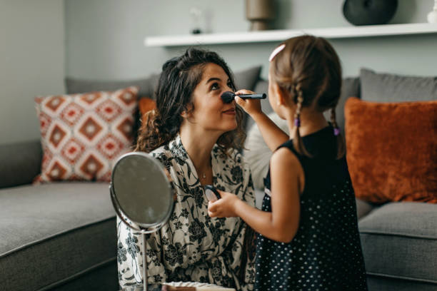 istock Mother and daughter putting on makeup 1360031470