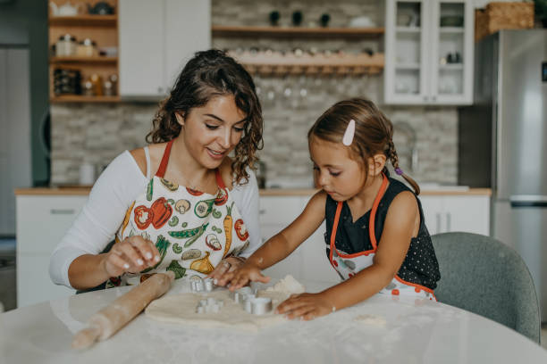istock Mother and daughter knead dough 1360031505