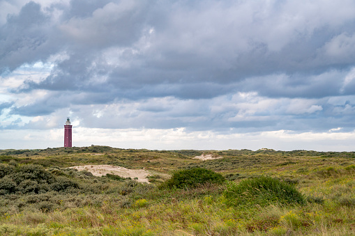 Lighthouse in the dunes of Goeree during a cloudy summer morning. The Westhoofd lighthouse is situated on the Dutch North Sea coast near Ouddorp on Goeree-Overflakkee island in South-Holland.