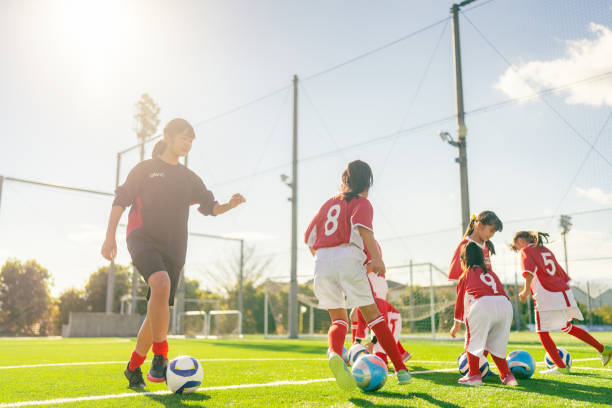 les membres de l’équipe féminine de football et de football des enfants s’entraînent et dribblent pour améliorer leurs compétences - dribbler sports photos et images de collection