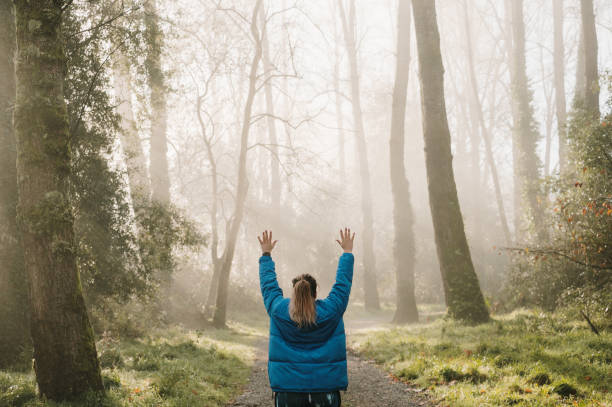 istock Woman with arms raised in a forest 1360034171