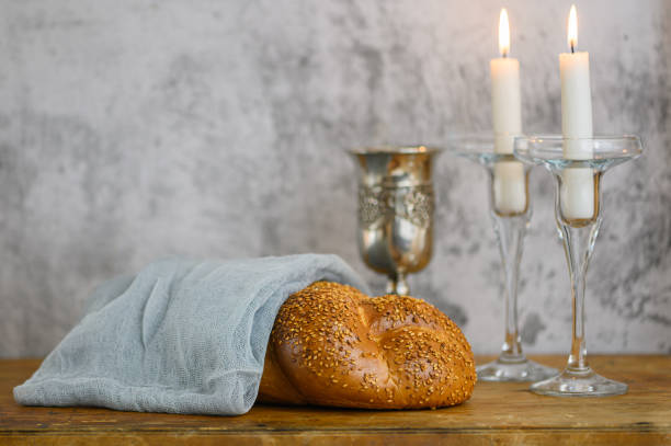 Shabbat Shalom - challah bread, shabbat wine and candles on wooden table stock photo