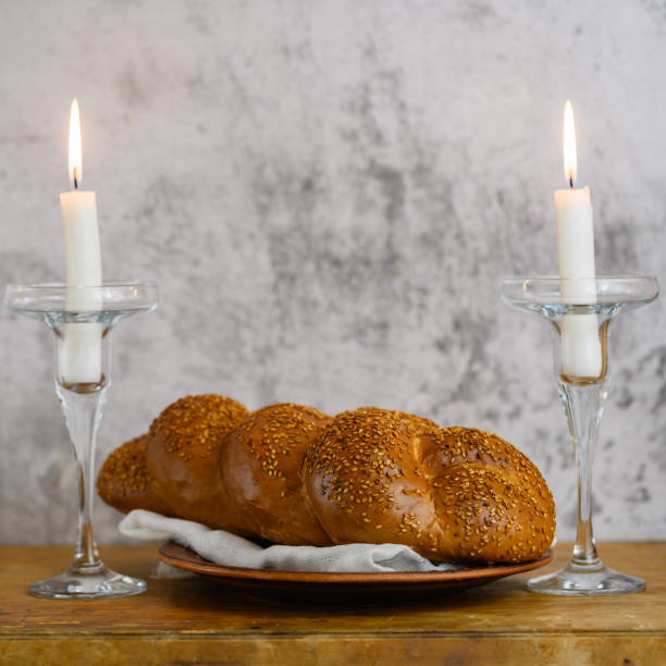 Shabbat Shalom - challah bread, shabbat wine and candles on wooden table stock photo