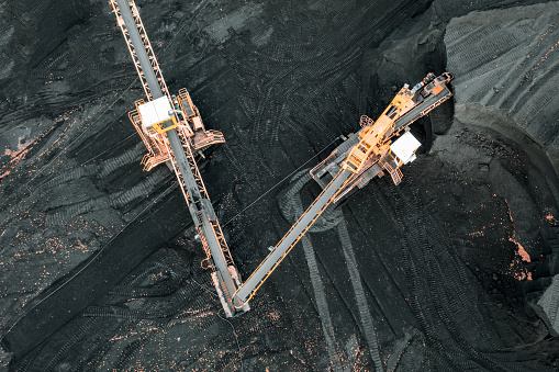 Grandes pilas de carbón, vista superior. Almacenamiento de carbón en el TPP, descarga y carga de carbón por excavadoras y cintas de transporte en el almacén del TPP. Fotografía aérea photo