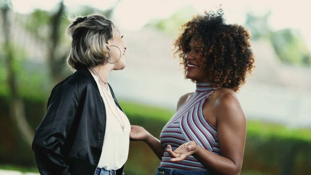 istock Two happy diverse women standing outside smiling 1360035091