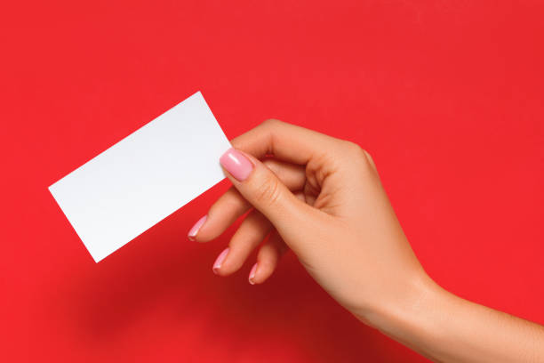 istock Female hand holding blank card on isolated red background 1360035709