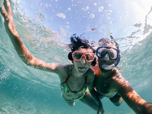 woman swimming in mauritius - vacations couple travel destinations snorkeling imagens e fotografias de stock
