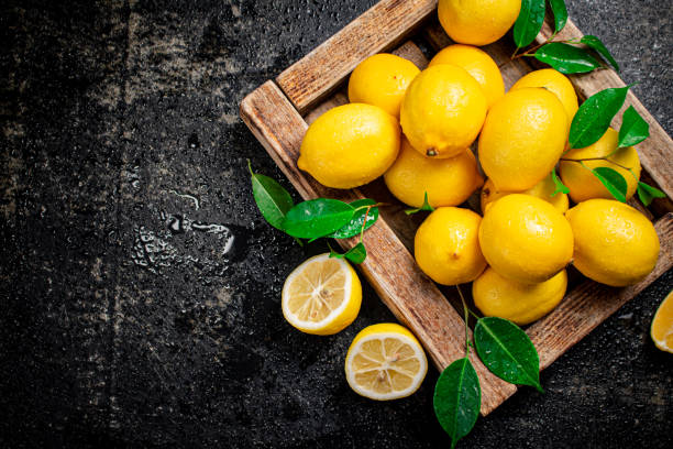 istock Lemons with leaves on a wooden tray. 1360039452