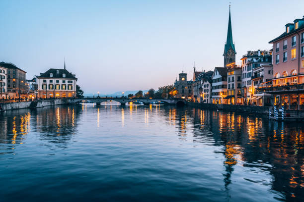 zurich, suiza paisaje urbano desde el río limmat - grossmunster cathedral fotografías e imágenes de stock
