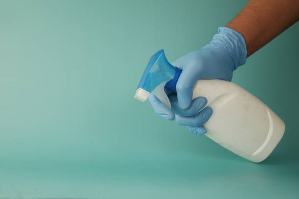 istock using disinfectant spray to clean table surface against light green background 1360044559