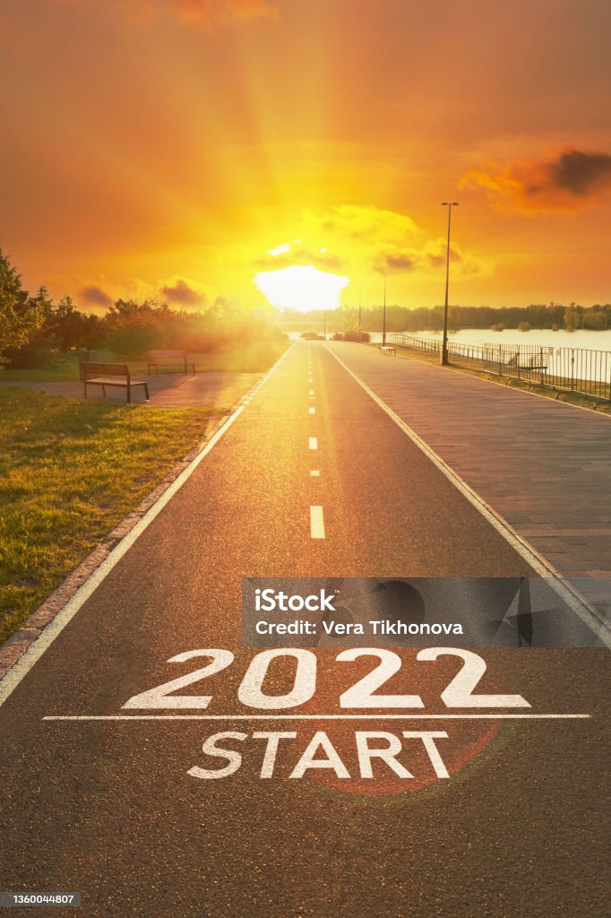 New year 2022 start concept New year 2022 start concept. The number of the 2022 year is written on the asphalt on the empty sports path in the bright rays of the sun. Motivational inscription for planning your life, business 2022 Stock Photo