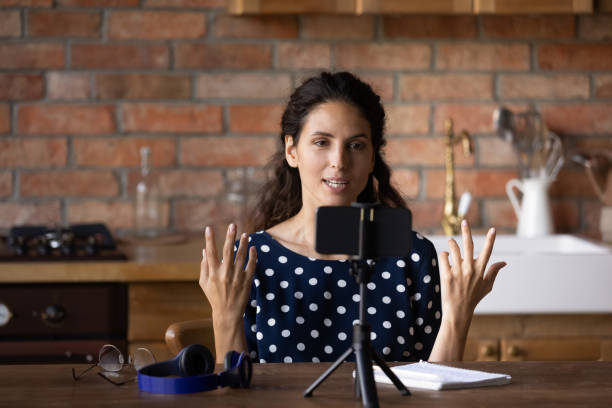 istock Concentrated young hispanic woman talking recording educational video. 1360045106