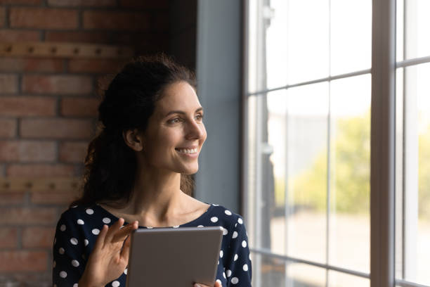 istock Dreamy happy young hispanic woman holding touchpad. 1360046139