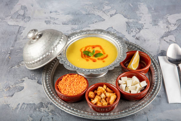 istock Lentil soup in a copper tray and copper bowl grey background. 1360046542