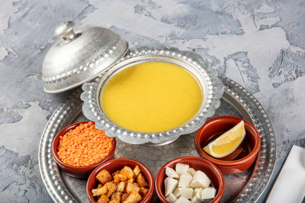 istock Lentil soup in a copper tray and copper bowl grey background. 1360049099