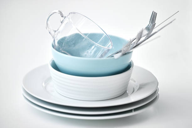 Empty yellow soup bowl and fork,spoon and table knife isolated on wooden table. Include clipping path.