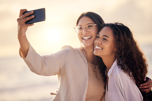 Shot of two beautiful young women taking a selfie together outside