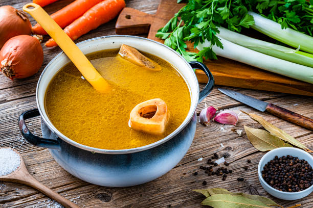 bouillon d’os dans une casserole - making soup photos et images de collection