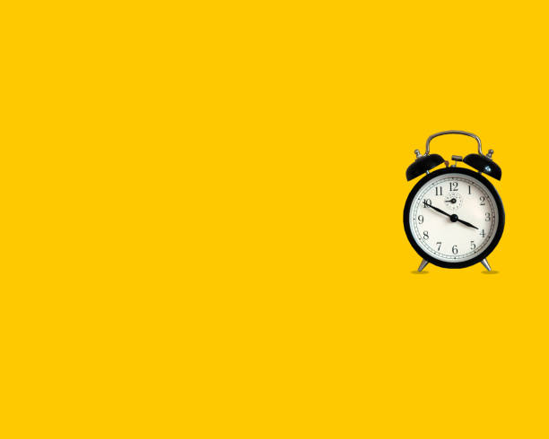 istock Top view old black alarm clock on bright yellow color background 1360053966