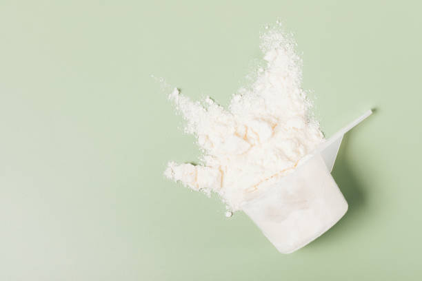 proteine del siero di latte in polvere nutrizione sportiva sparsa dalla misurazione - bevanda proteica foto e immagini stock