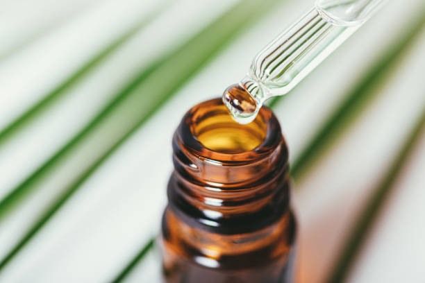 istock Pipette drips essential oil into bottle against background 1360059141