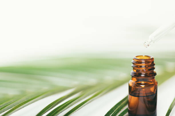 istock Closeup essential oil drops into bottle from pipette 1360059166