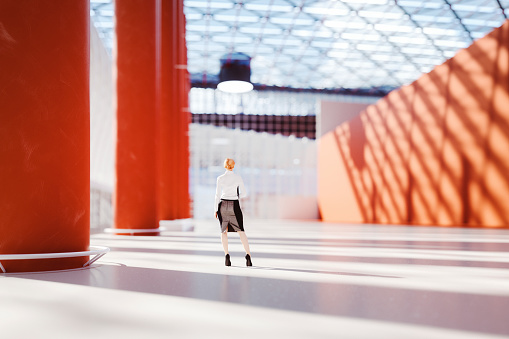Businesswoman standing in big empty convention center. This is entirely 3D generated image.