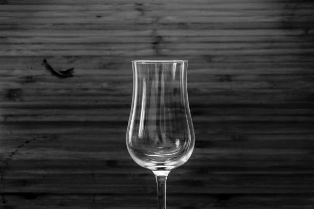 istock Transparent drinking glass on brown wooden old table with white backround 1360059724