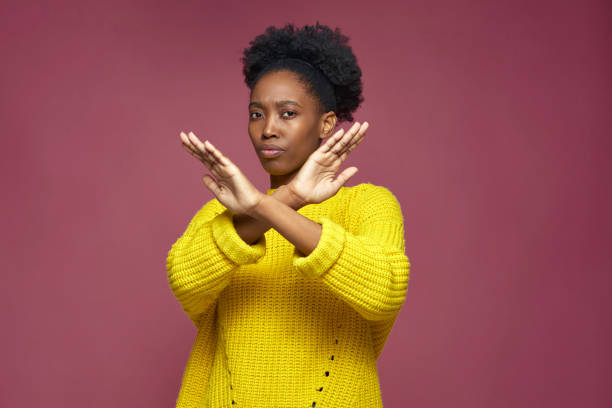 Serious young african american woman show stop finish gesture by crossed hands, protest against racial discrimination Serious young african american woman showing stop finish gesture by crossed hands, protesting against gender and racial discrimination. protests. High quality photo refusing stock pictures, royalty-free photos & images