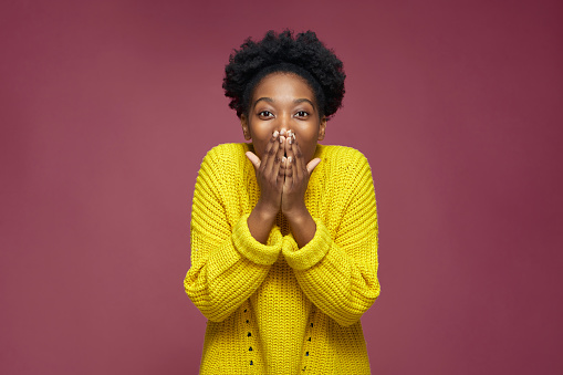 Amazed excited young african american girl surprised by good news cover mouth on pink studio background. Incredible sale. High quality photo