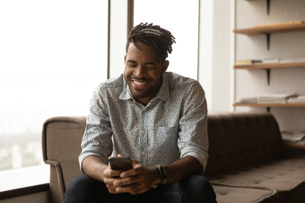 istock African man smiling look at smartphone chatting online 1360060899