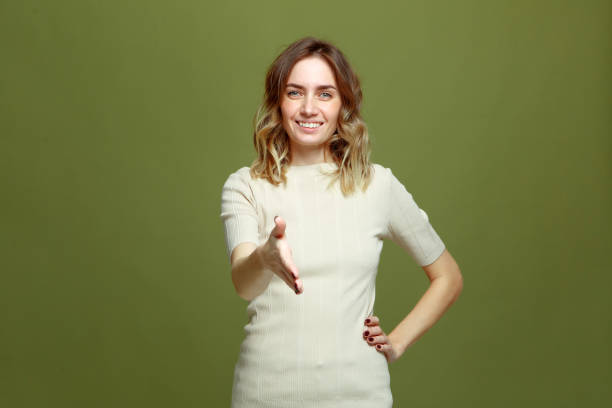 Smiling young woman offering hand for greeting, handshake, welcoming client or partner. Successful deal, introduction Smiling young woman offering hand for greeting, handshake, welcoming client or partner. Successful deal, introduction. High quality photo social grace stock pictures, royalty-free photos & images