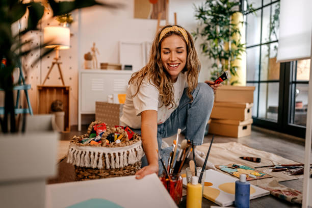 istock Artist looking at painting while making artwork 1360061927