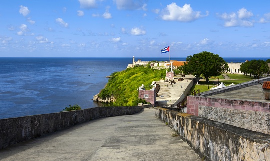 Havana, Cuba, November 18, 2017: View of the La Cabaña Fortress (Spanish: Fortaleza de San Carlos de la Cabaña) which is an 18th-century fortress complex located on the eastern side of the harbor entrance in Havana. The fort is part of the Old Havana World Heritage Site which was created in 1982. In the background is the Castillo De Los Tres Reyes Del Morro.