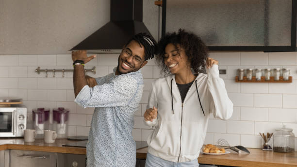 istock Happy African couple dancing together in modern kitchen 1360062792
