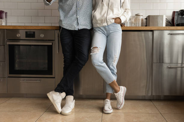 Unrecognizable African couple standing on tiled floor in kitchen