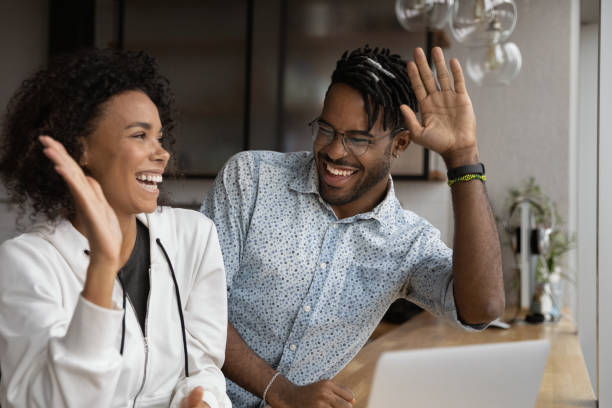高5を与えるラップトップのニュースで読んで幸せなアフリカのカップル - men laughing african descent color image ストックフォトと画像