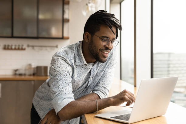 istock Handsome hipster guy using laptop watch webinar entertaining online content 1360063444
