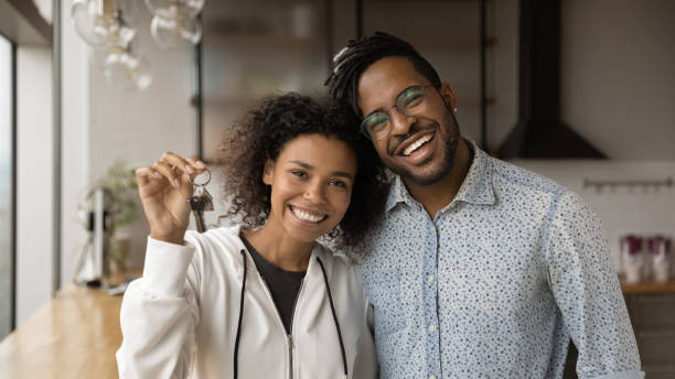 istock African married young couple holding keys pose on camera 1360063447