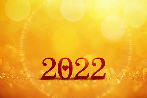 New Year 2022 greeting on gold colored bokeh balls at the background Holiday and new year concept backdrop with twinkling bright bokeh circles