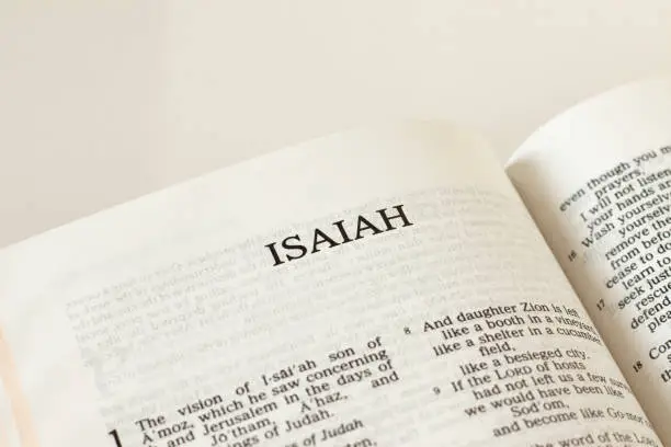 Open Holy Bible Isaiah prophet Book Old Testament Scripture on white background. Christian biblical concept of prophecy, trust, and faith in God Jesus Christ. Reading the Word of the LORD. A close-up.